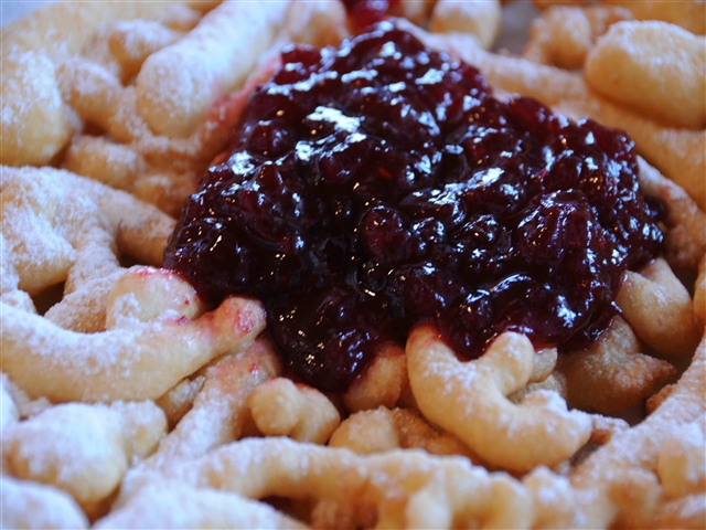Un piatto pieno zeppo di strauben. L'impasto tutto attorcigliato, con in mezzo una montagna di lucida, ed invitante marmellata di frutti di bosco!